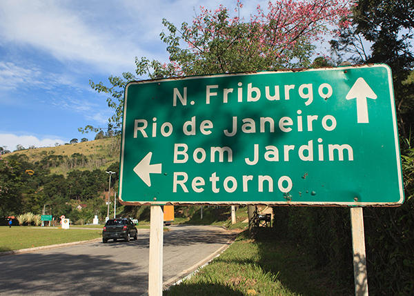 Wegweiser mit Ortsnamen: N. Friburgo, Rio de Janeiro (Pfeil geradeaus), Bom Jardim, zurück (Pfeil nach links)