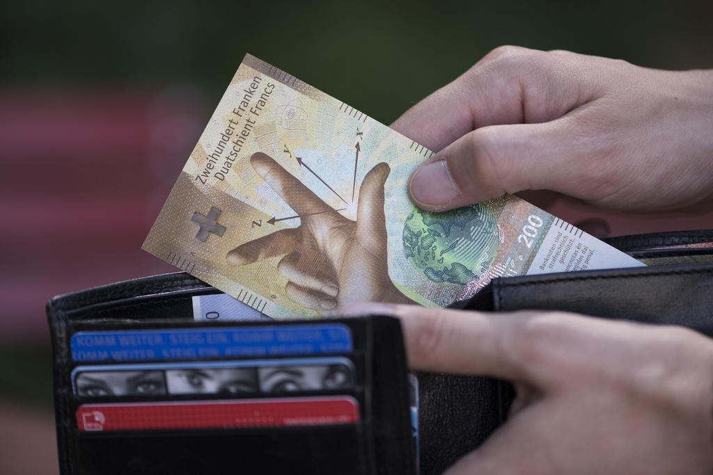 Une main sort un billet de 200 francs d un porte-monnaie