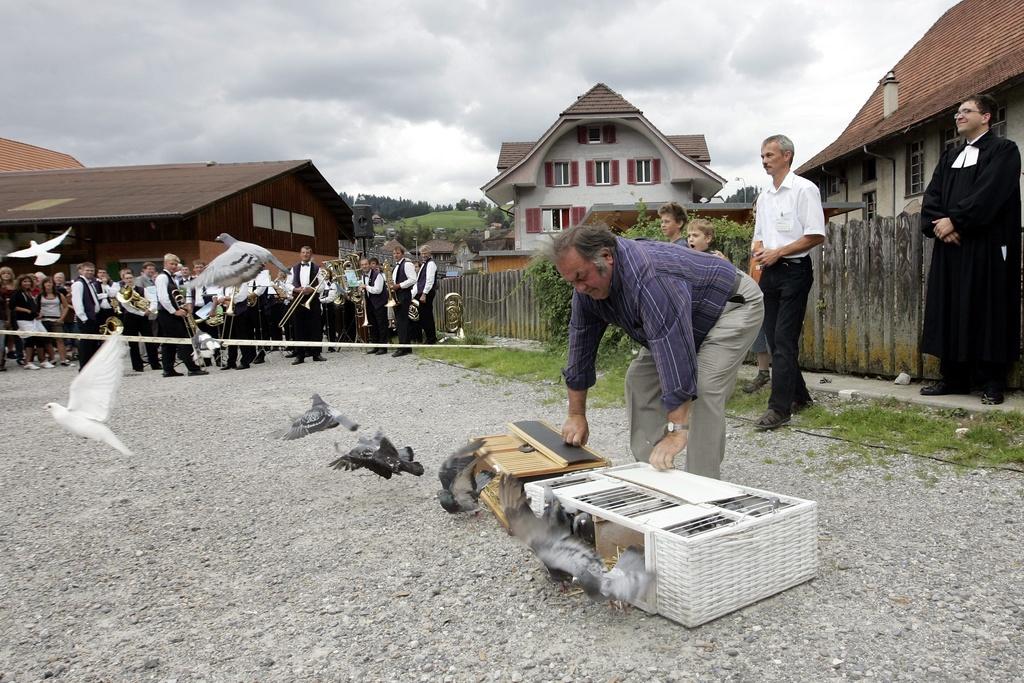 Man releases doves from cages placed on the ground.