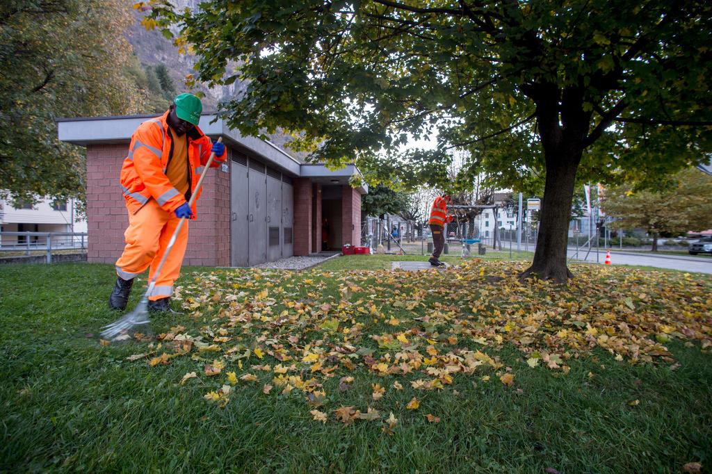 Asylum seekers clean a park in Biasca, canton Ticino, in 2017