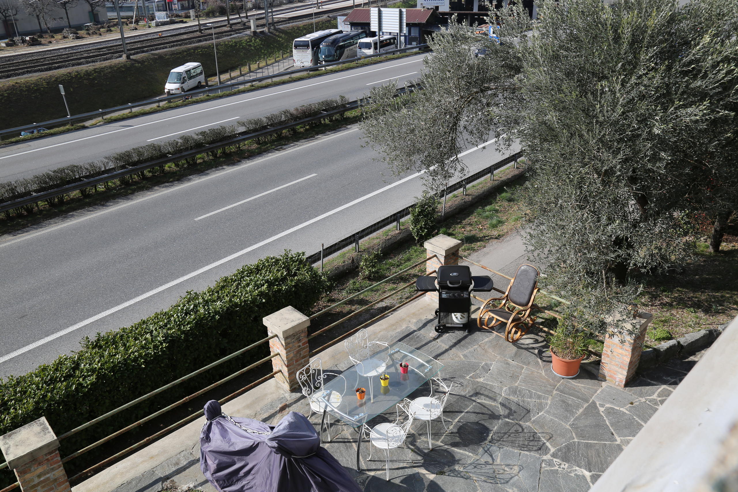 Una terrazza con tavolo e sedie, che dà direttamente sull autostrada.