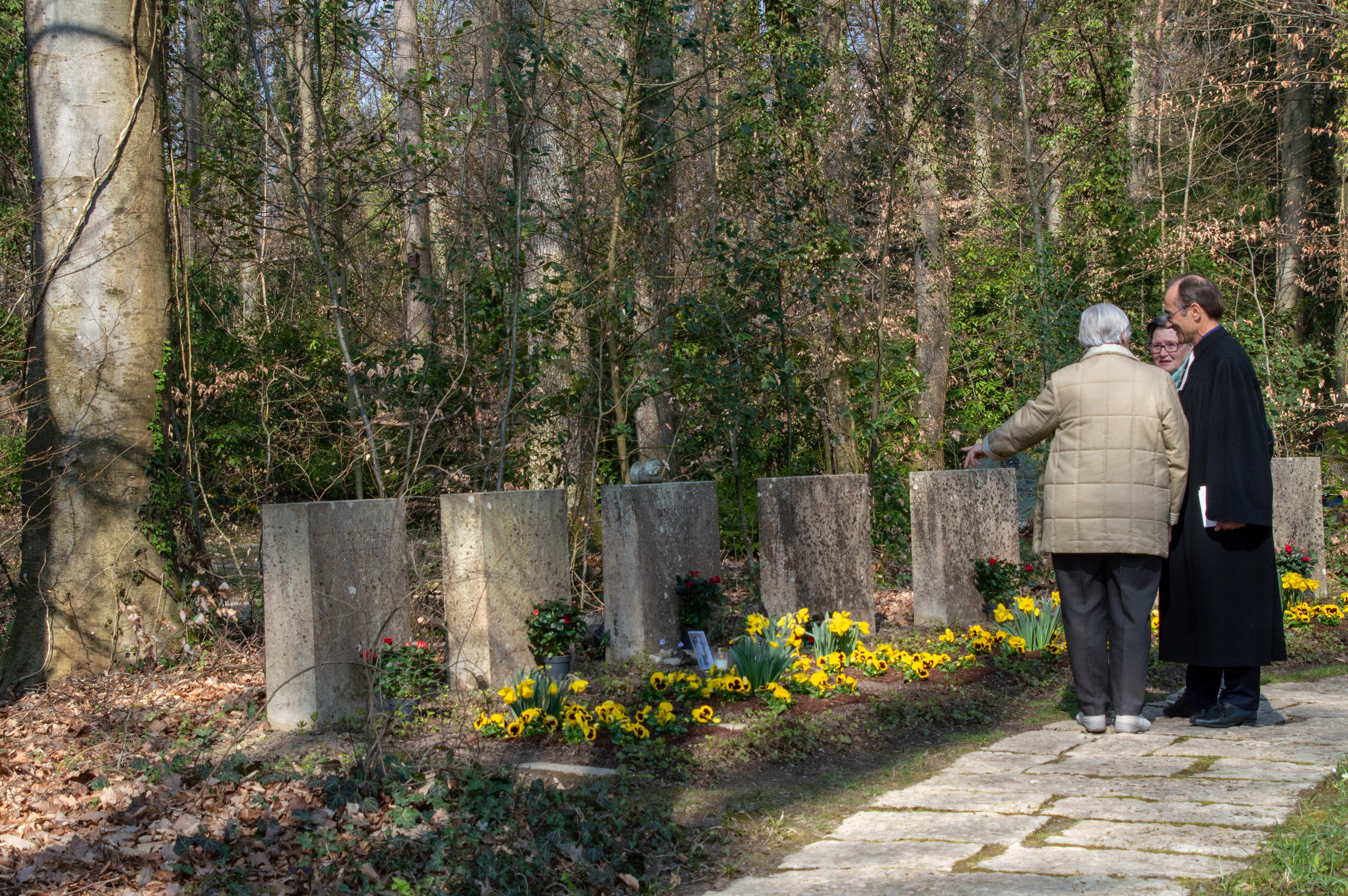 Besucher stehen vor Gräbern