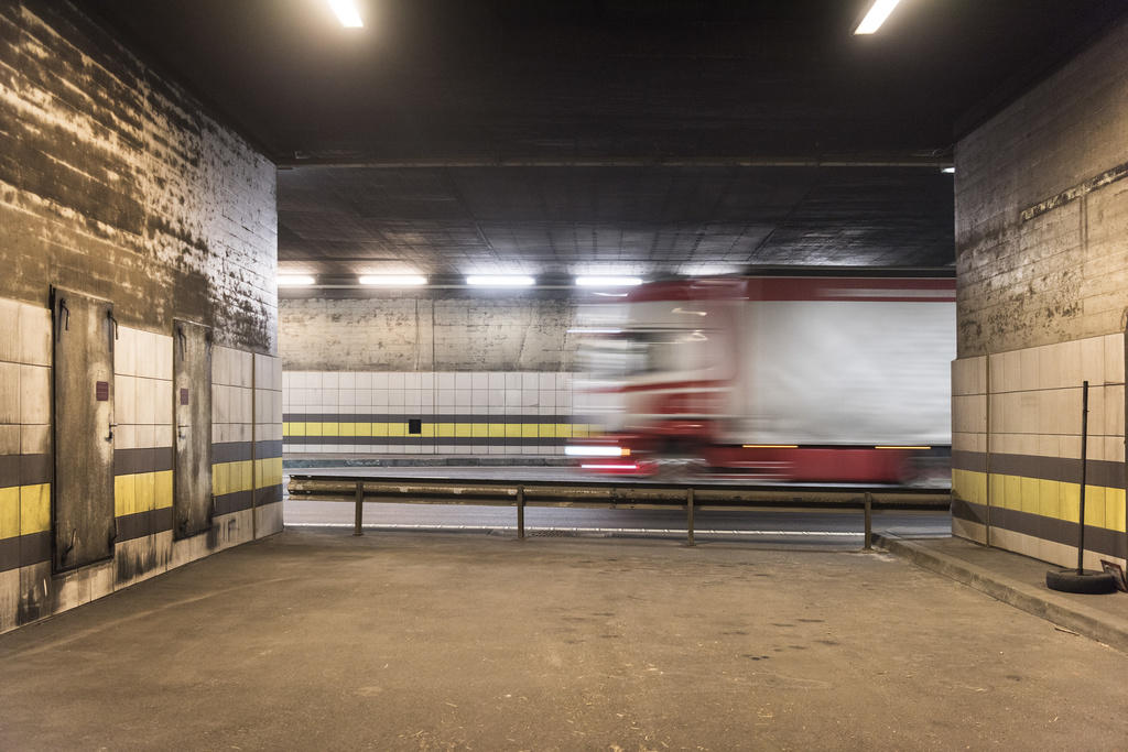 Un camion, fotografato da una piazzola nei pressi del portale della galleria, sfreccia verso la sinistra della foto