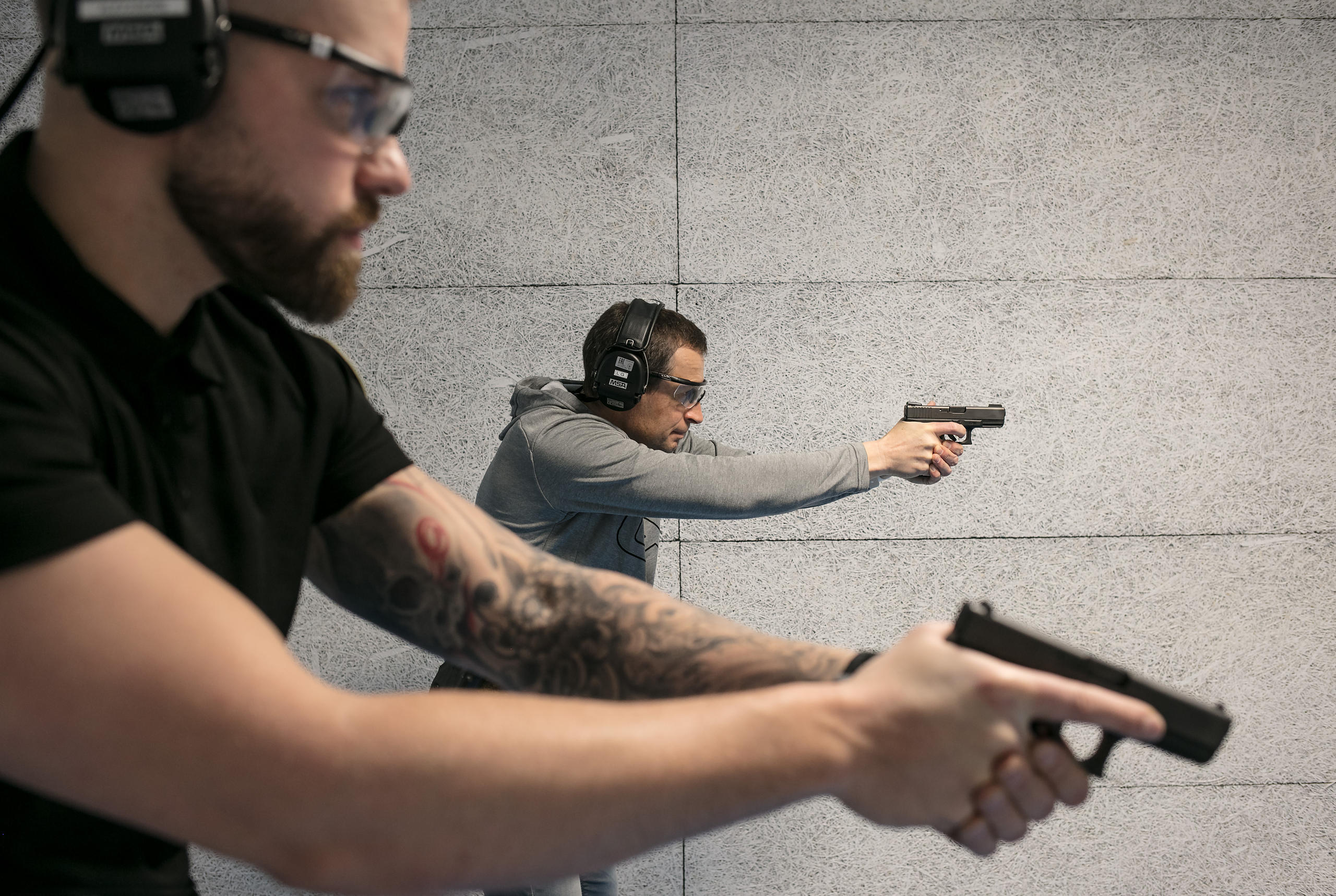 Two men aiming pistols