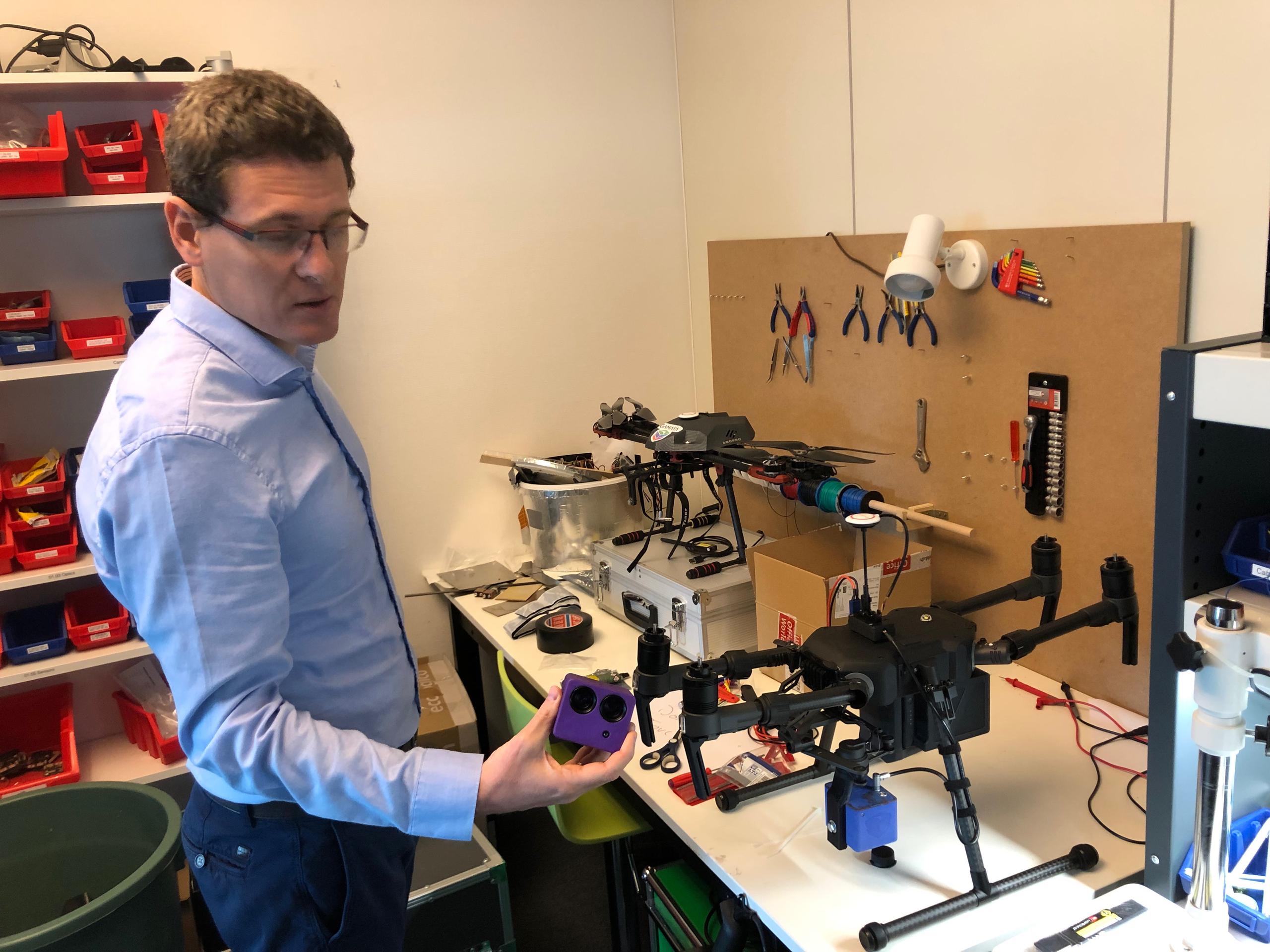 un uomo insalla una telecamera su un drone