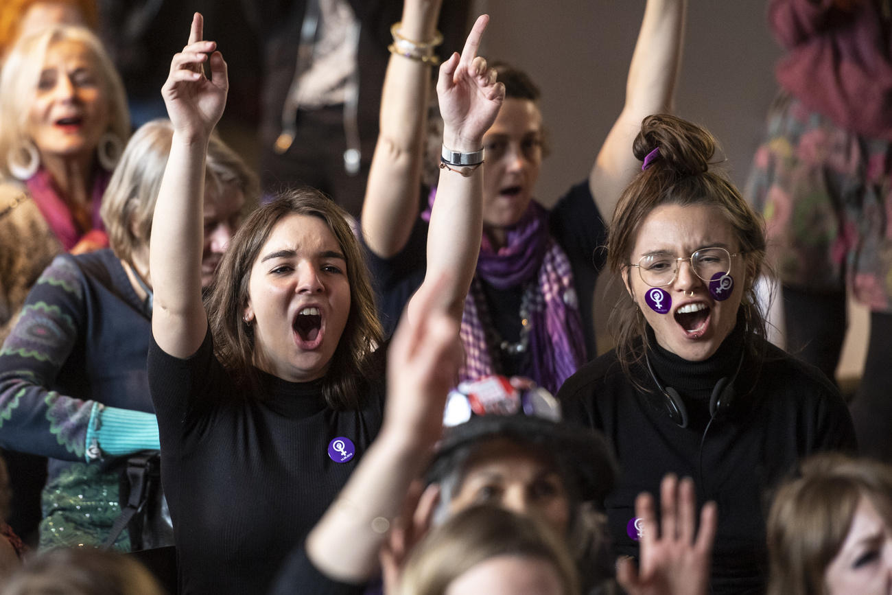 Des femmes crient en levant les mains