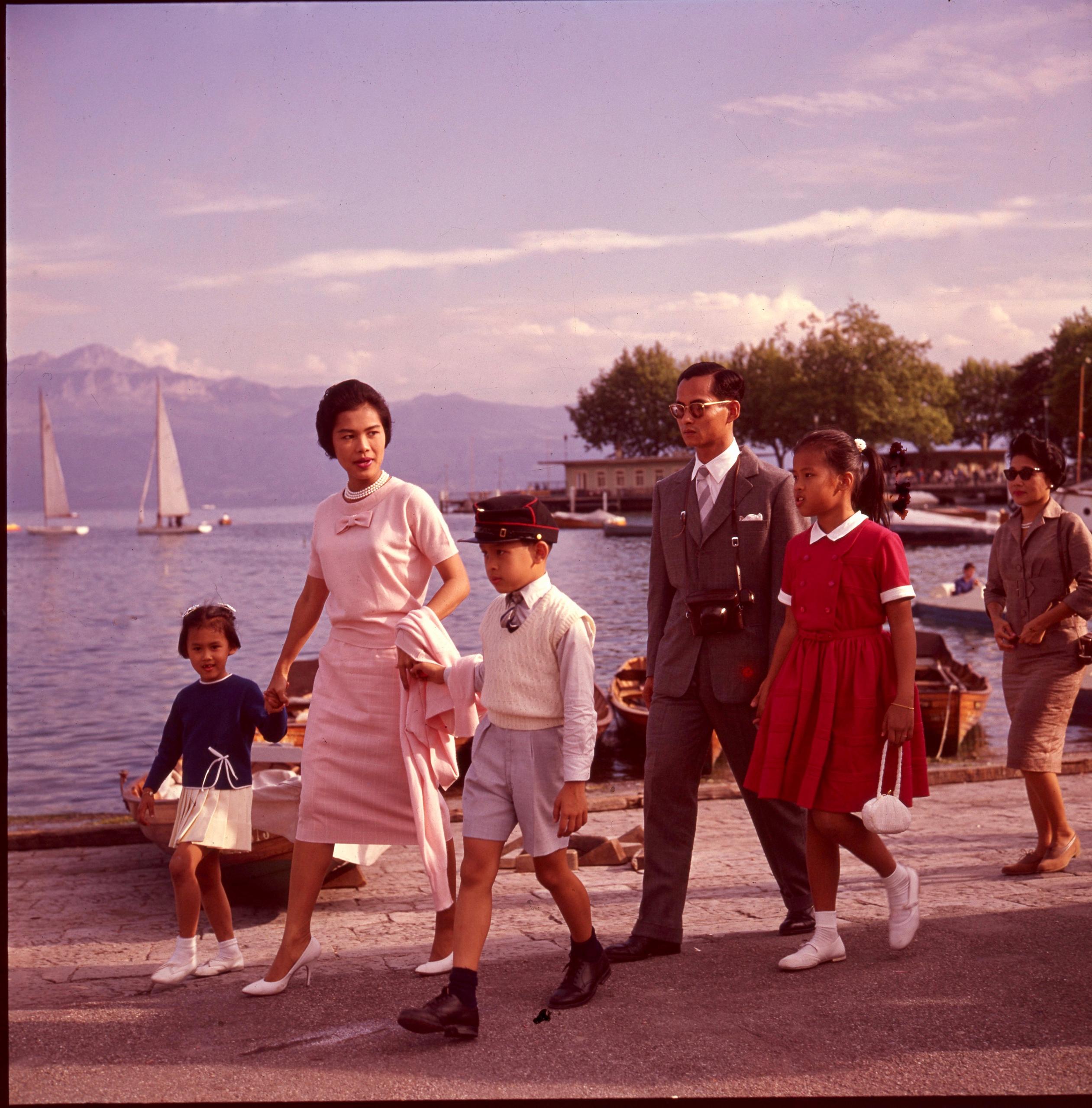 due adulti con i figli passeggiano in riva al lago