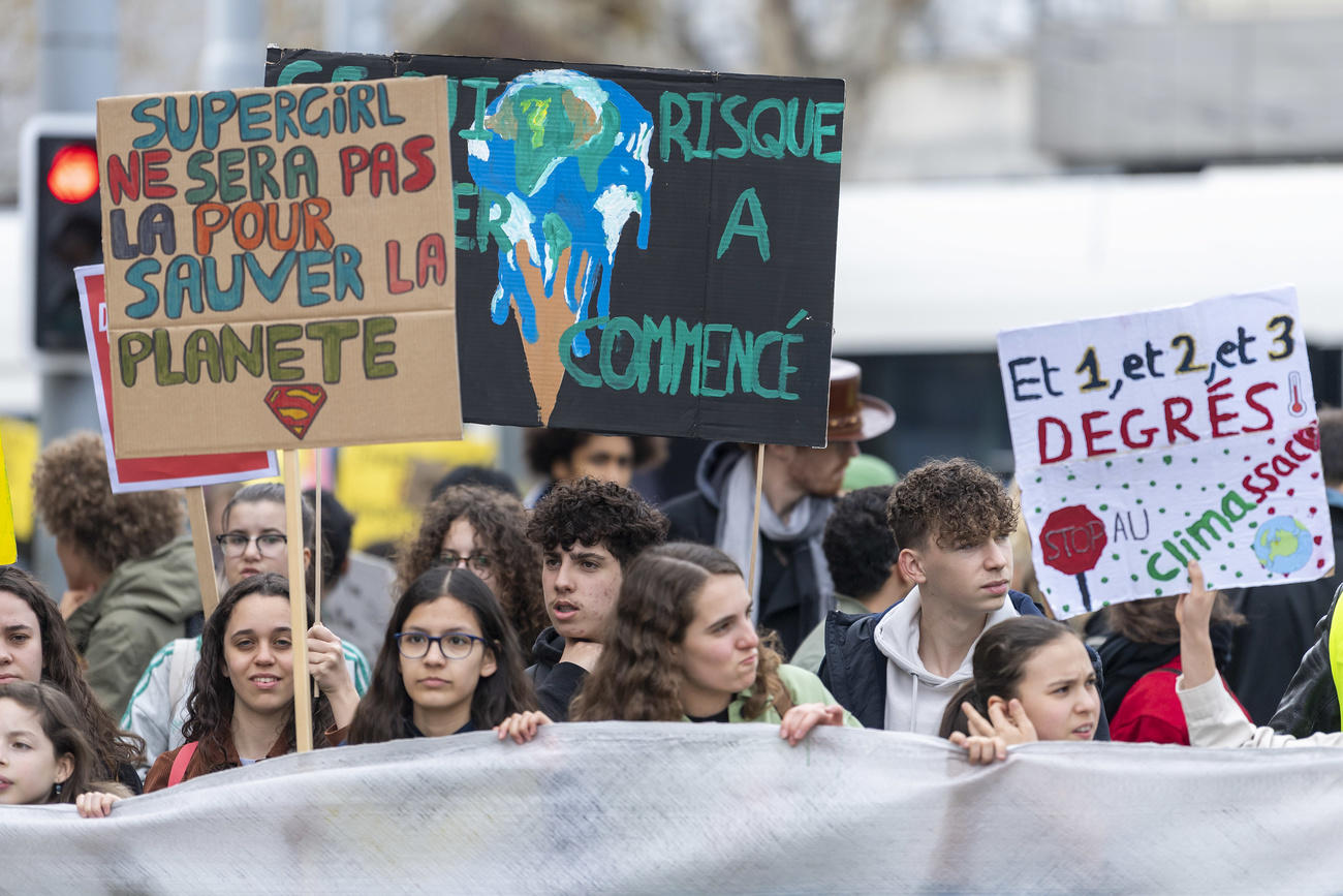 Ragazzi in corteo innalzano cartelloni che denunciano il riscaldamento climatico.