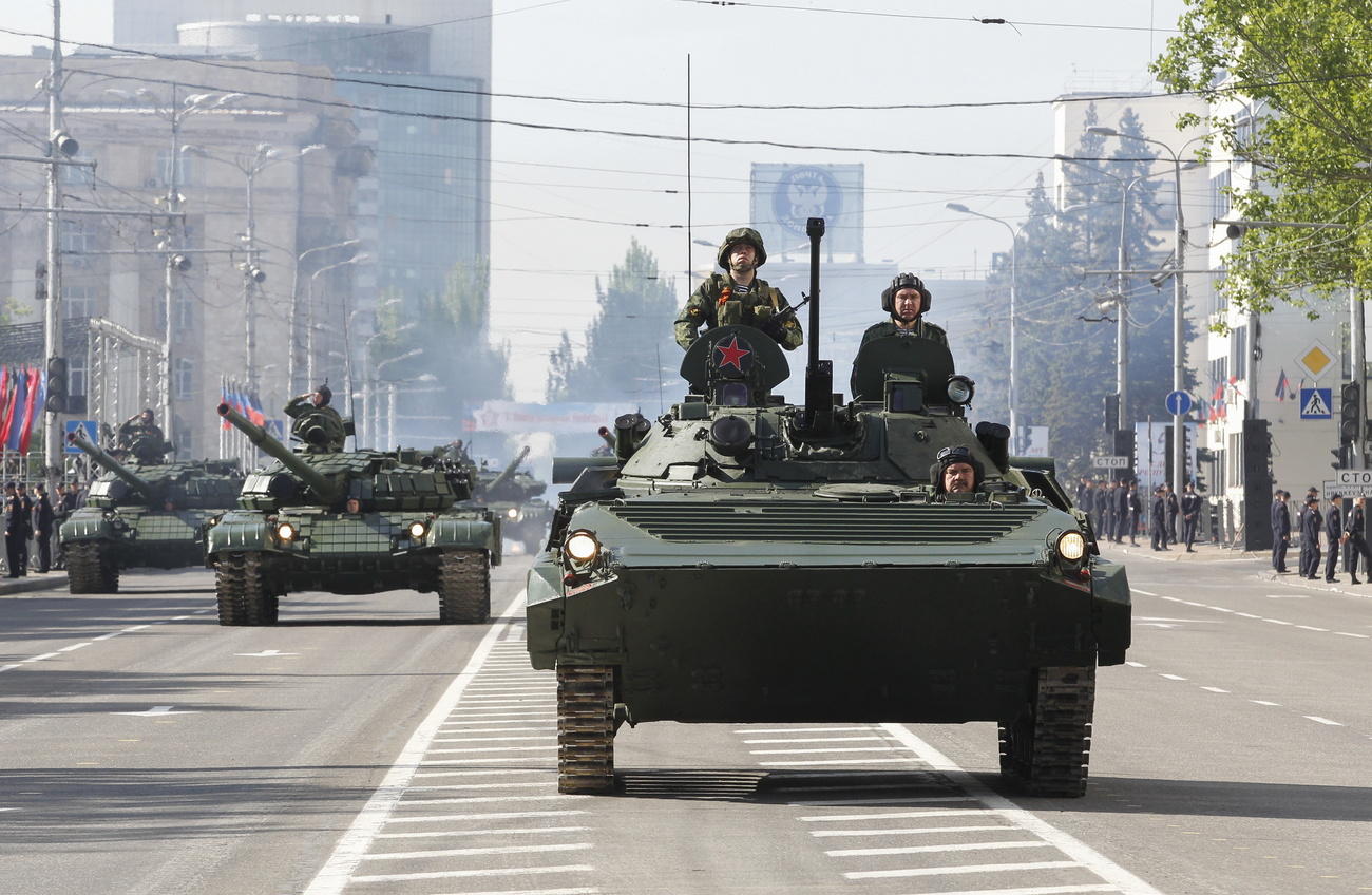 Tanks drive down a road in Donetsk