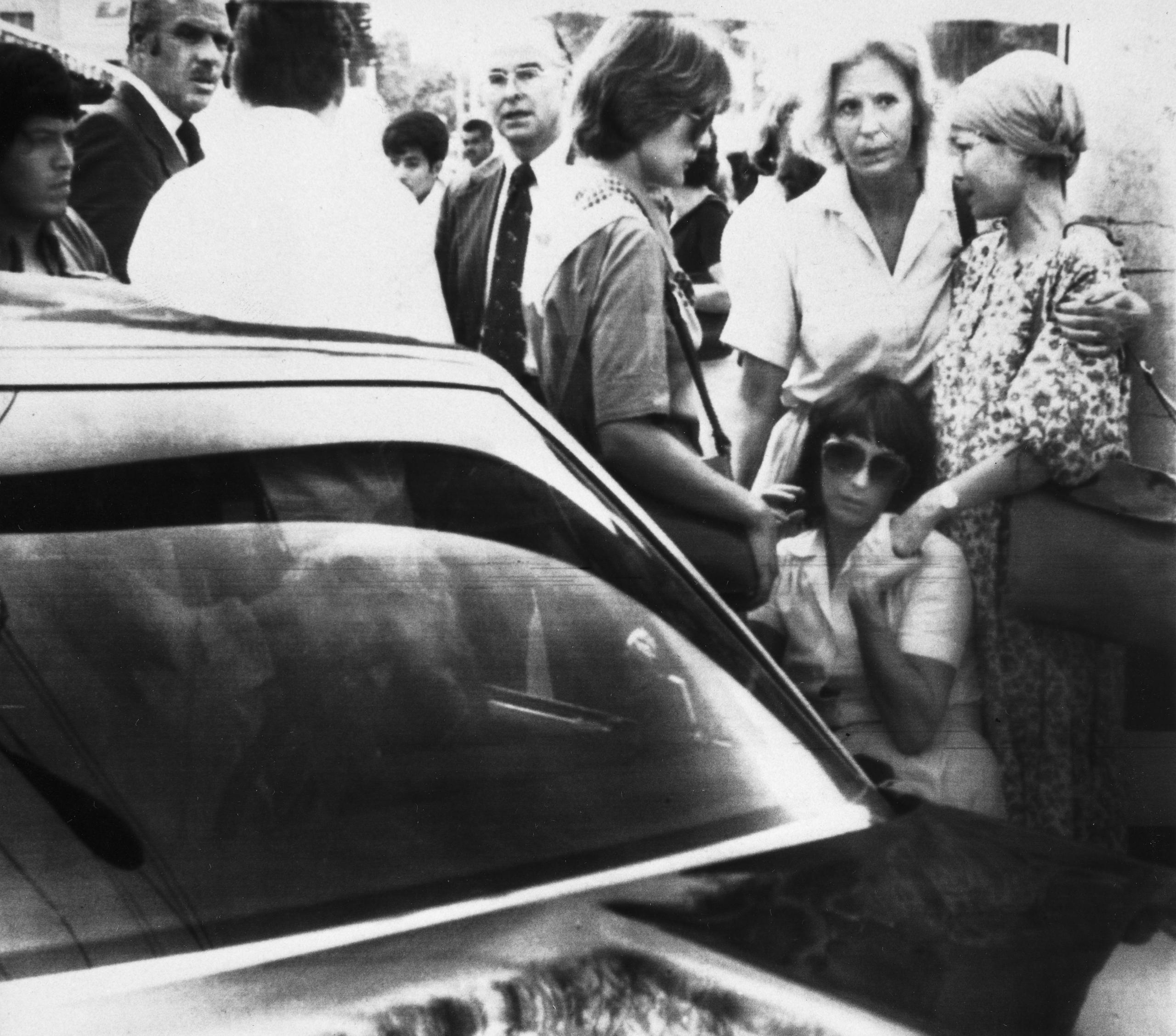 Un grupo de personas junto al automóvil del diplomático abatido