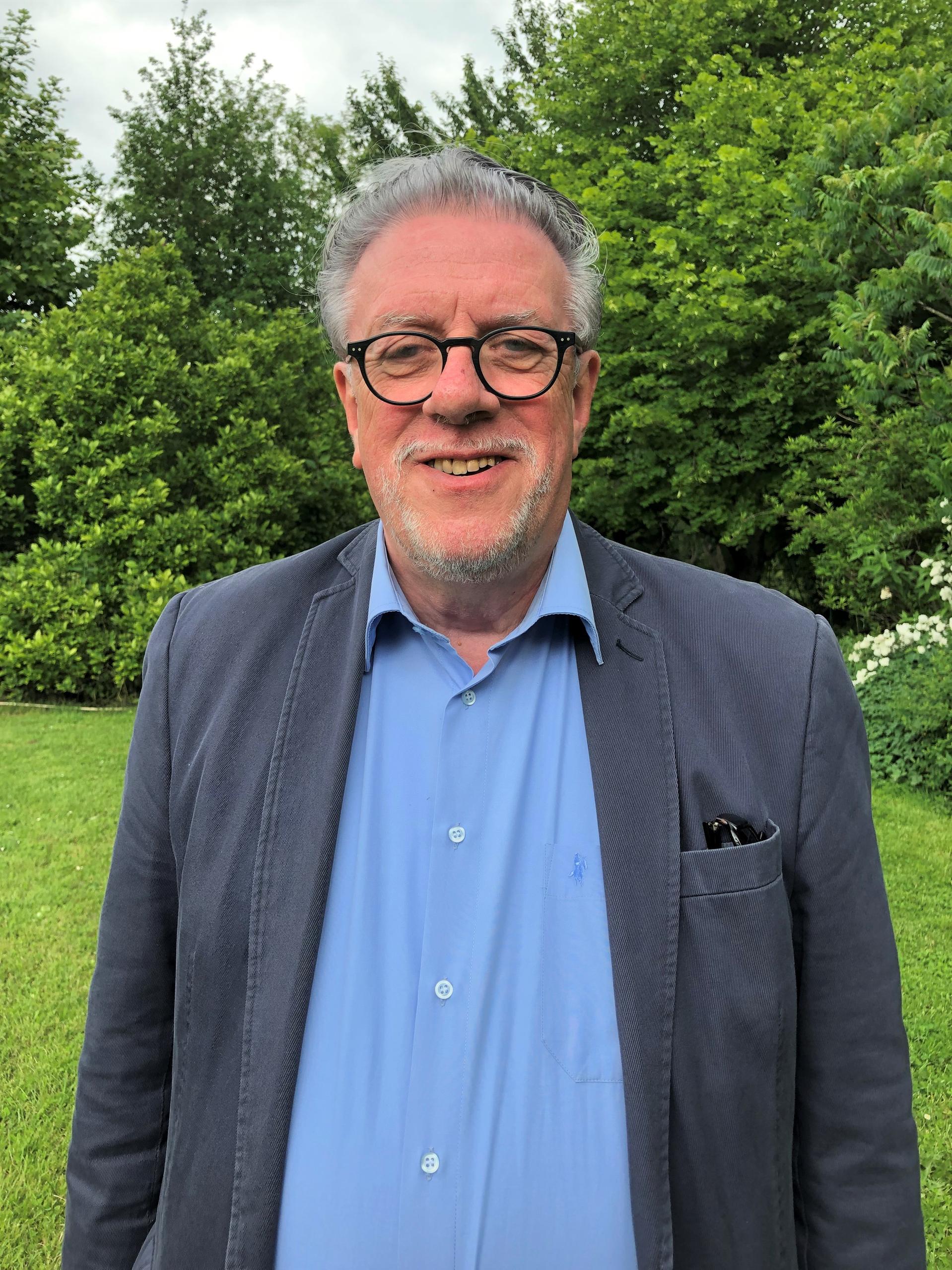 Un homme avec des lunettes dans un jardin