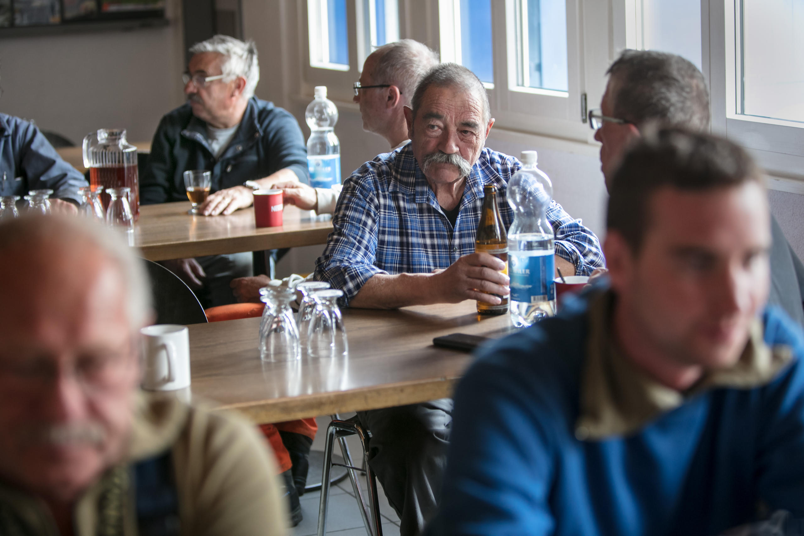 Des hommes boivent de l eau et des bières dans une cantine