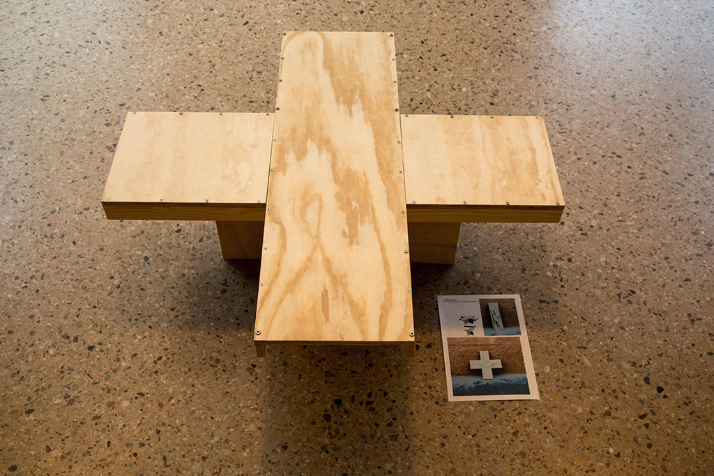 Mesa de madeira construída no formato da cruz suíça.