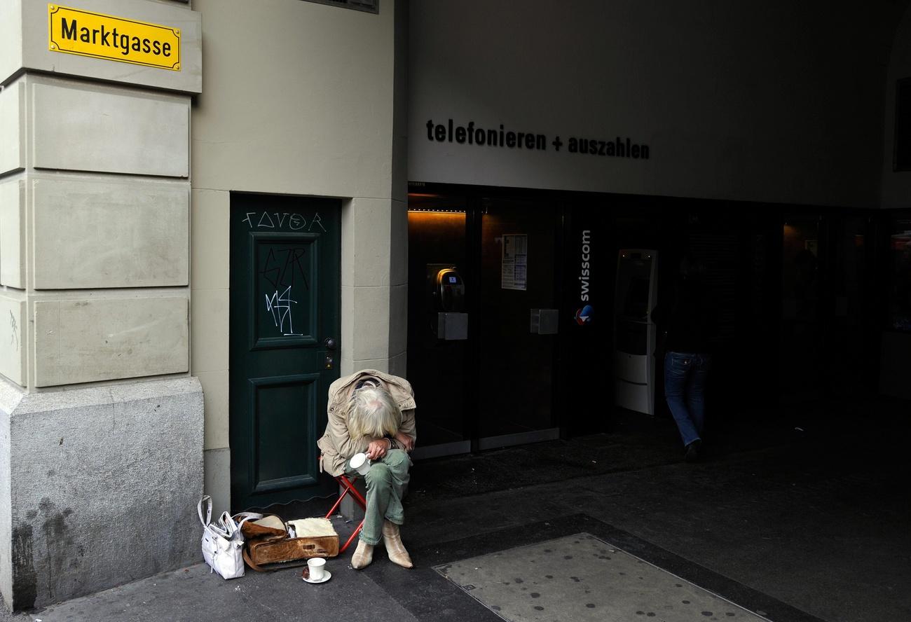 Una mujer indigente sentada en la calle