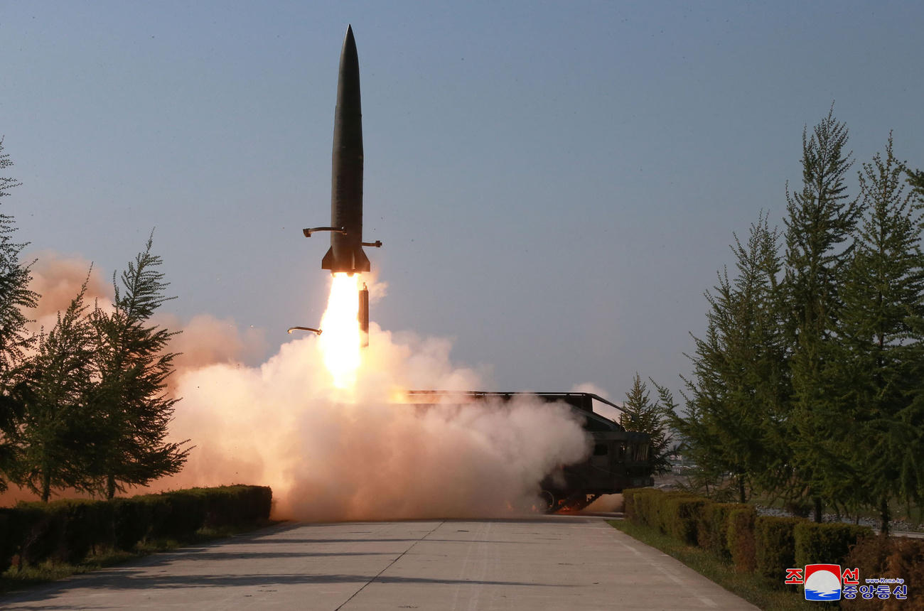 Immagine di un missile che decolla; in primo piano la strada che porta alla piattaforma/base; di lato, vegetazione