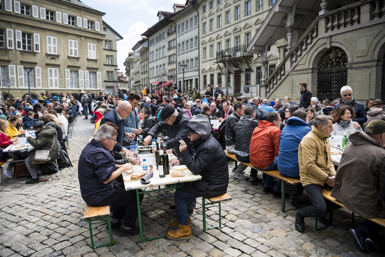 Personnes mangeant sur une place