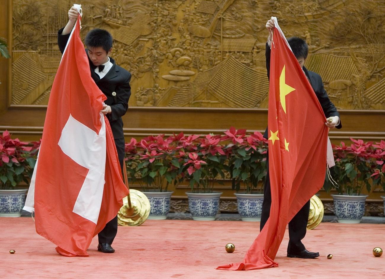中瑞双边正式会面礼宾工作人员整理两国国旗。