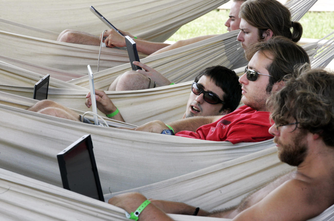 People in hammocks using computers