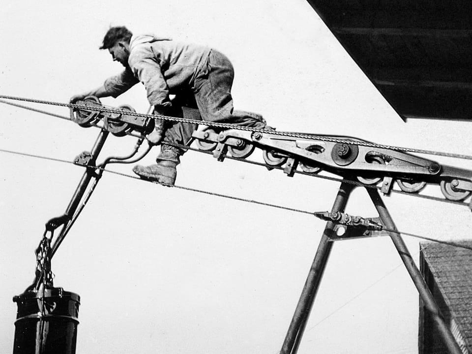 Ein Mann klettert auf dem Seil einer Bahn