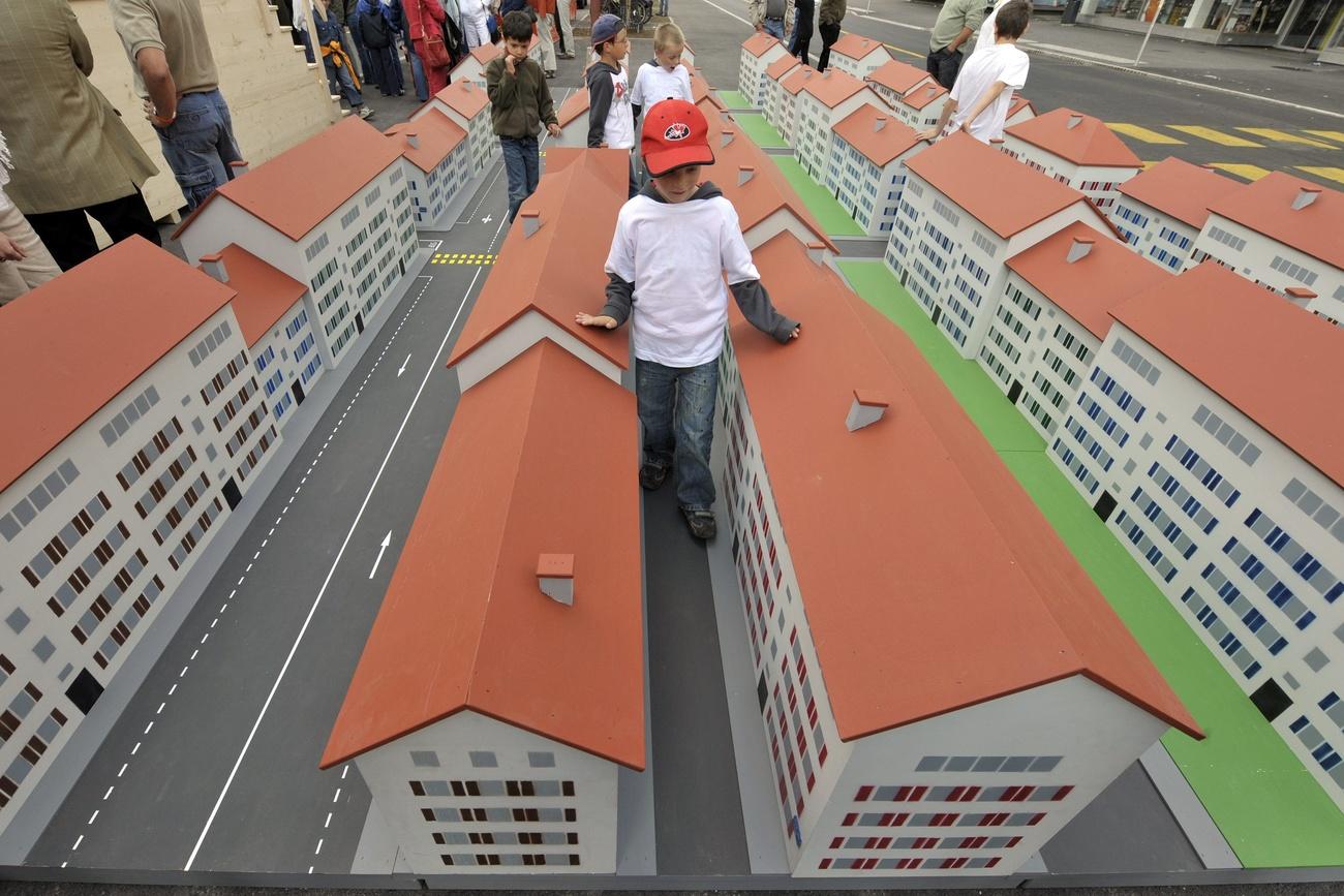 أطفال يتفحصون نموذجًا لمدينة لا شو دو فون
