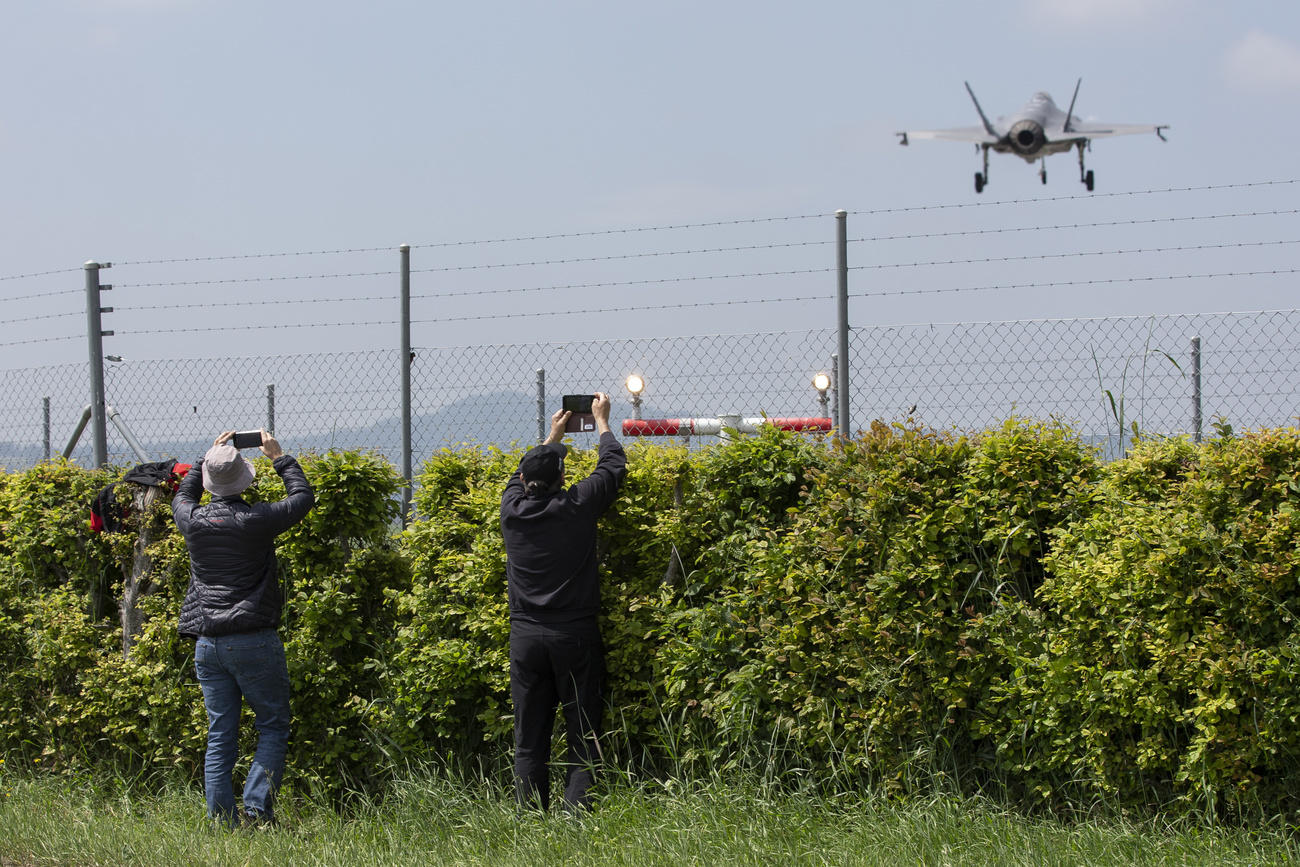 Plane spotters take pictures of a Lockheed Martin F-35A fighter jet