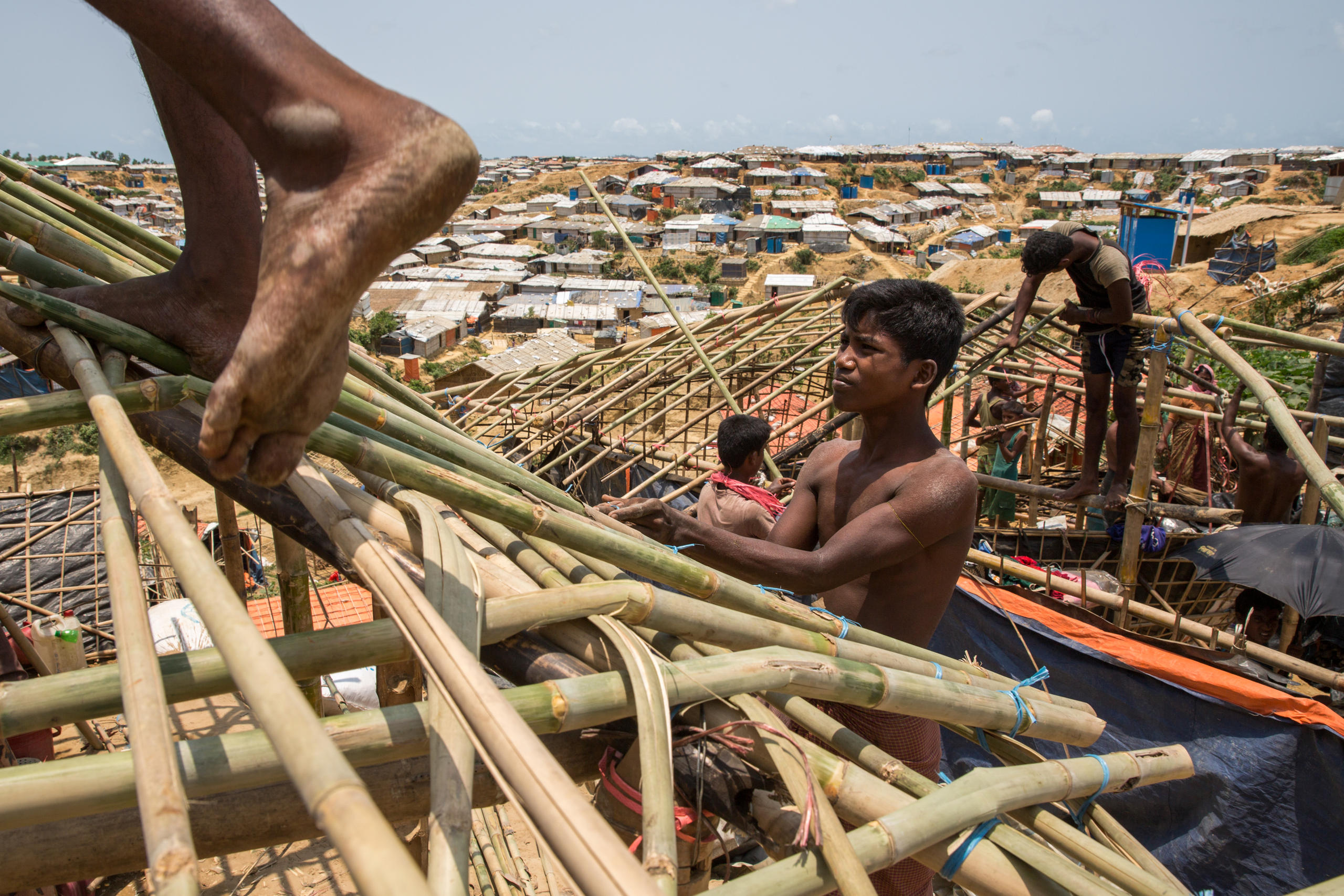 難民キャンプのなかで竹の家を作る男性