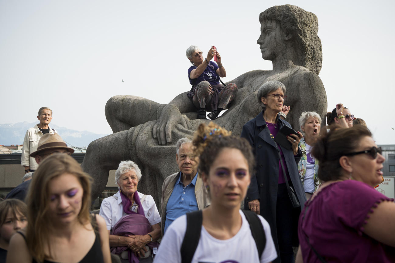 Mujeres avanzan al lado de un monumento femenino