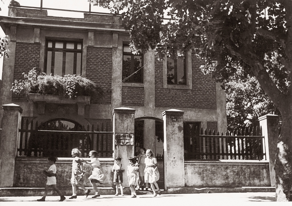 Niños frente a una escuela en una imagen antigua