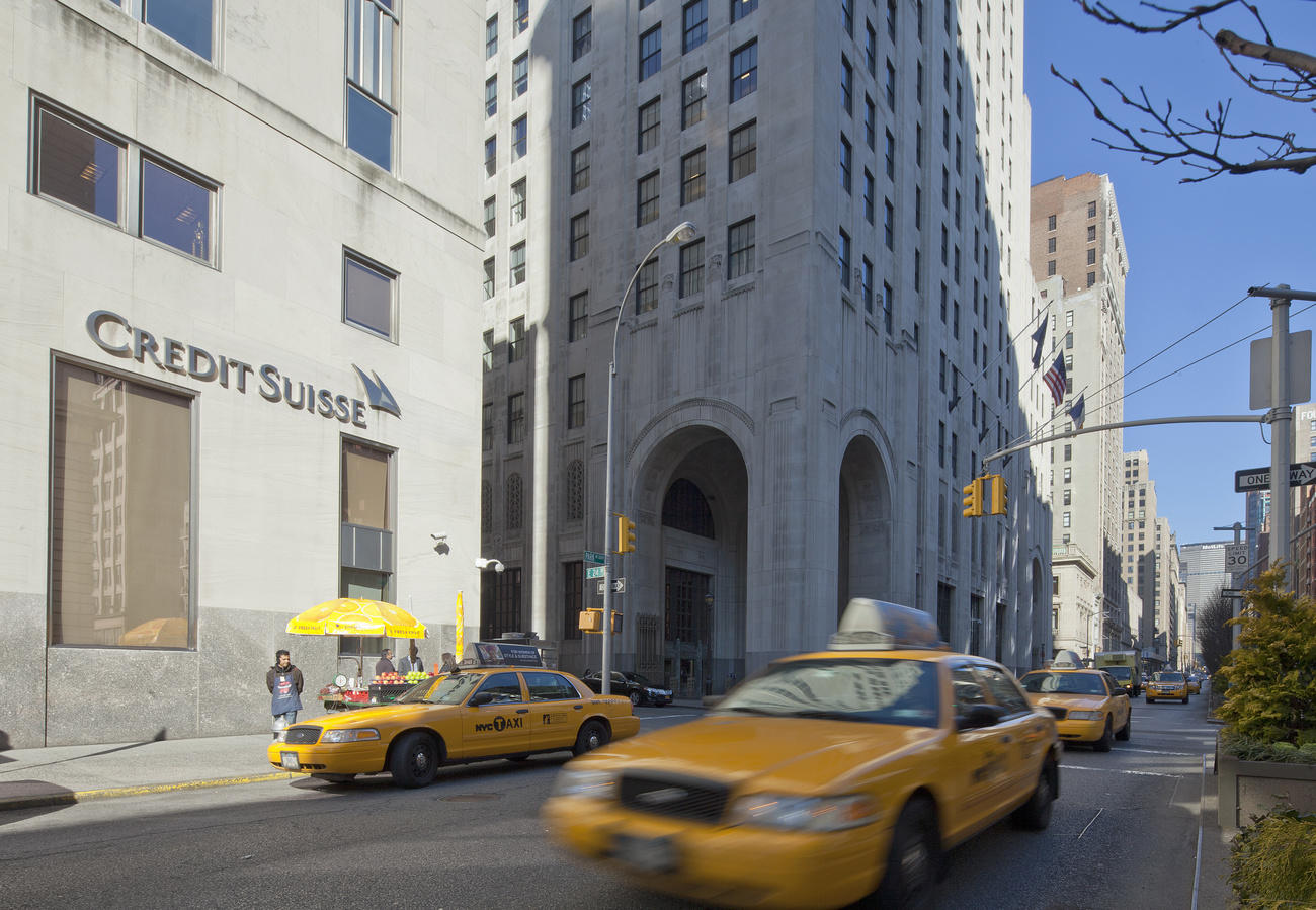 Pedestrians and a taxi in front of the building of Credit Suisse bank in New York City