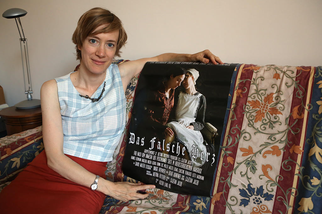 Frau auf Sofa mit Filmplakat Das falsche Herz