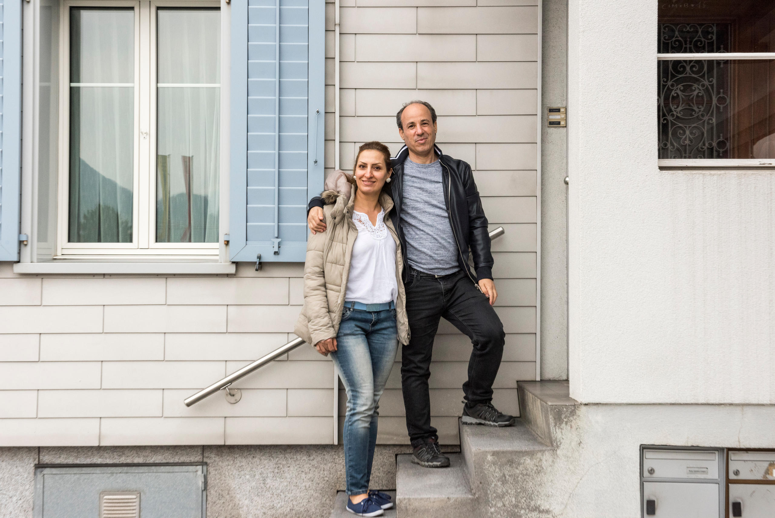 رجل وامرأة يقفان على درج بيت