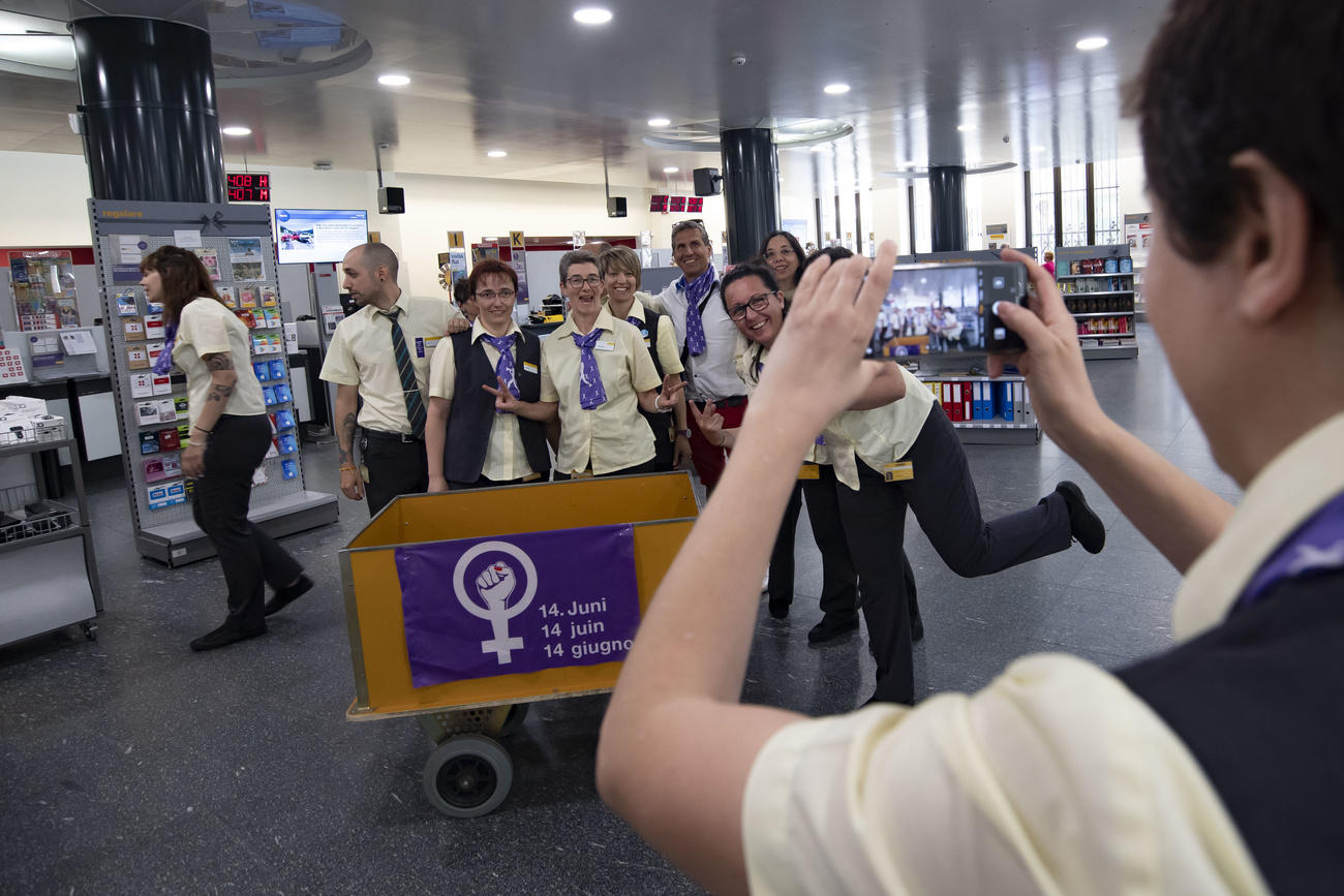 Trabajadoras de Correos se toman una foto con afiche feminista