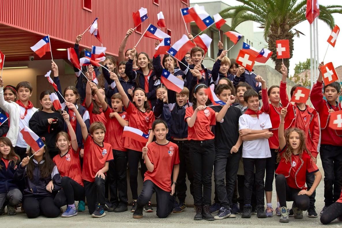 Grupo de niños con bamderas de Chile y de Suiza