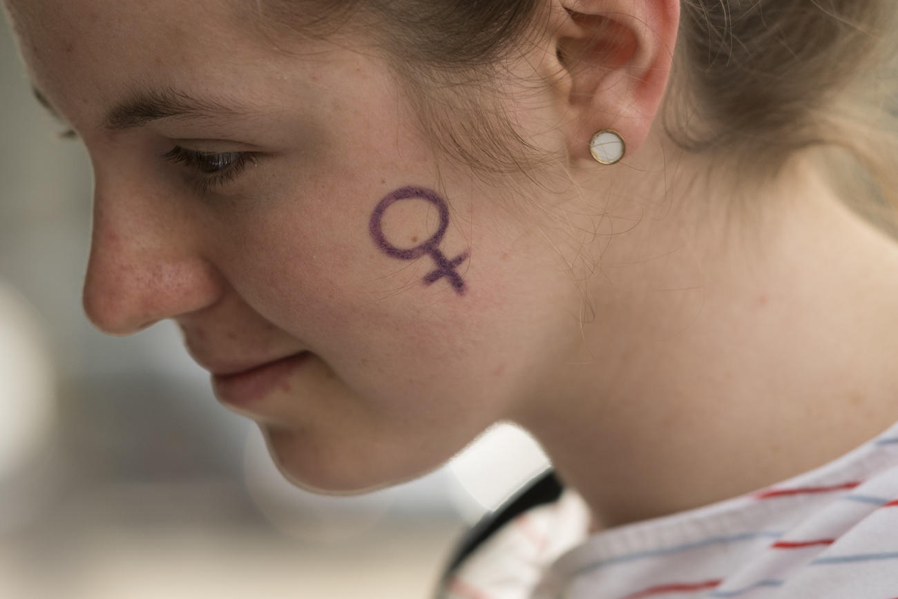 Young woman withe the female sign painted on cheek