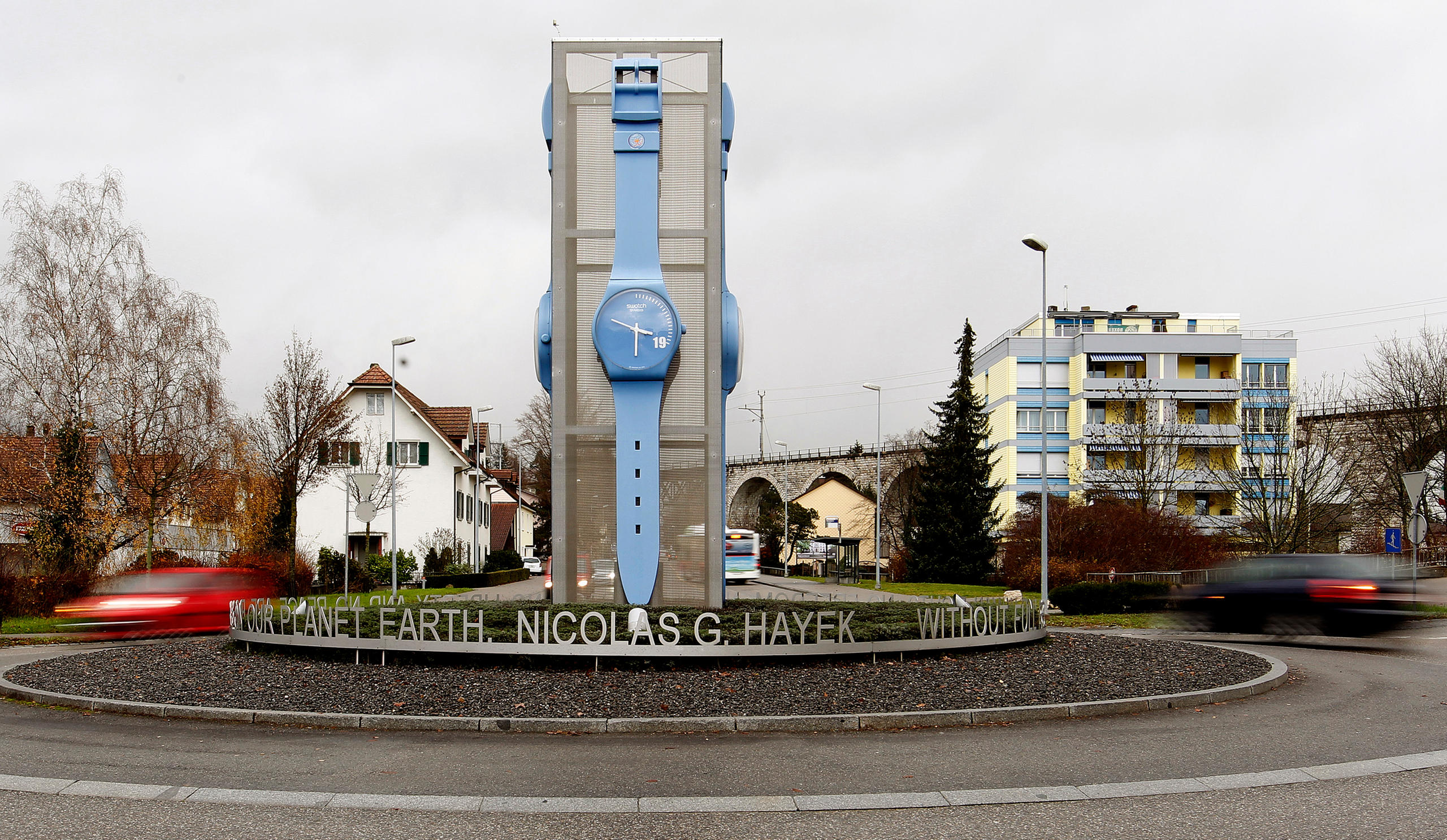 a giant Swatch watch placed in the centre of a roundabout