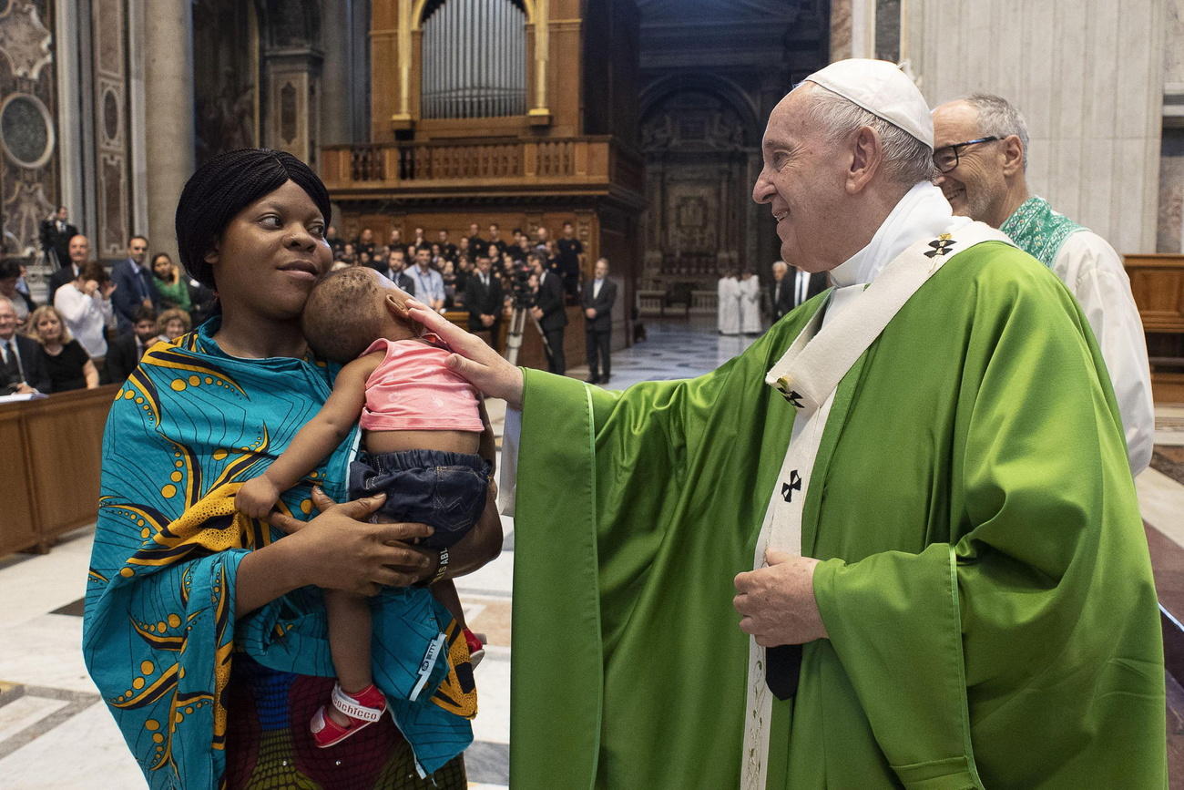 Papa Francesco benedice un bimbo di colore in braccio alla mamma.