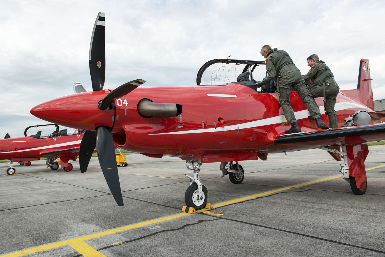 Red PC-21 training aircraft with instructor and student