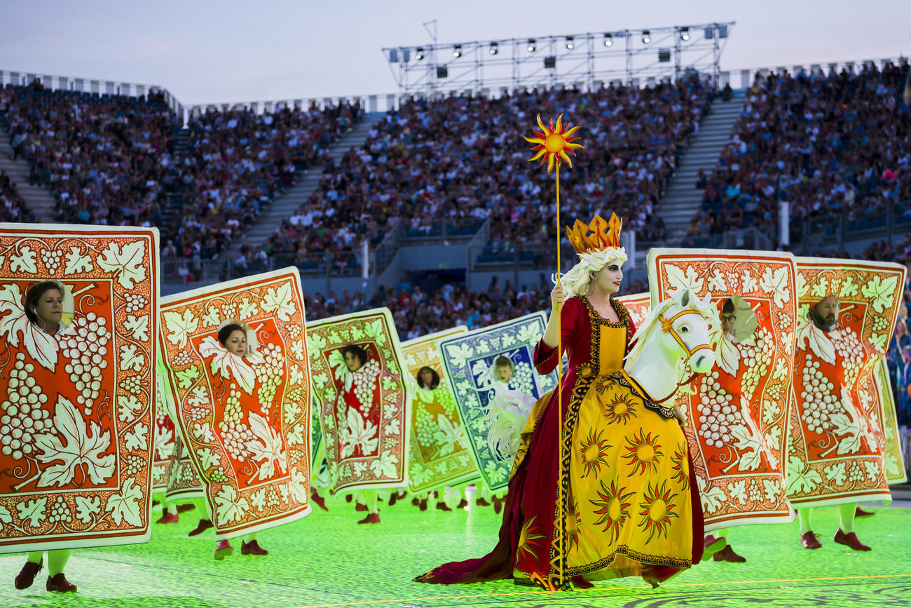 Scène du spectacle de la Fête des vignerons avec une troupe de figurants déguisés en cartes à jouer