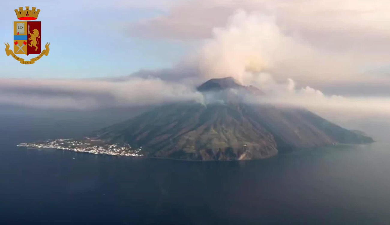 Veduta aerea di un isola-vulcano con colori dell alba e colonna di fumo ben visibile