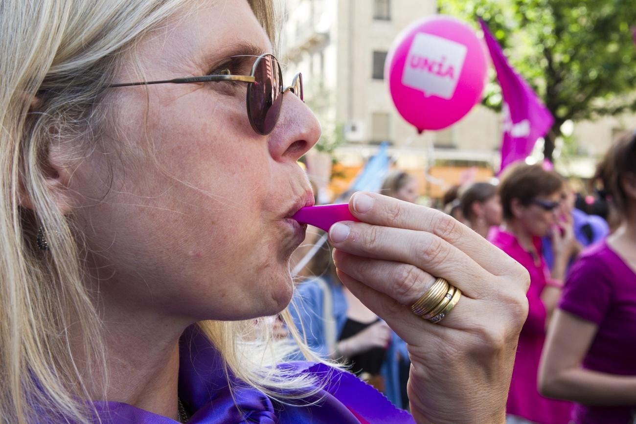 Frau mit violetter Pfeife am Frauenstreik