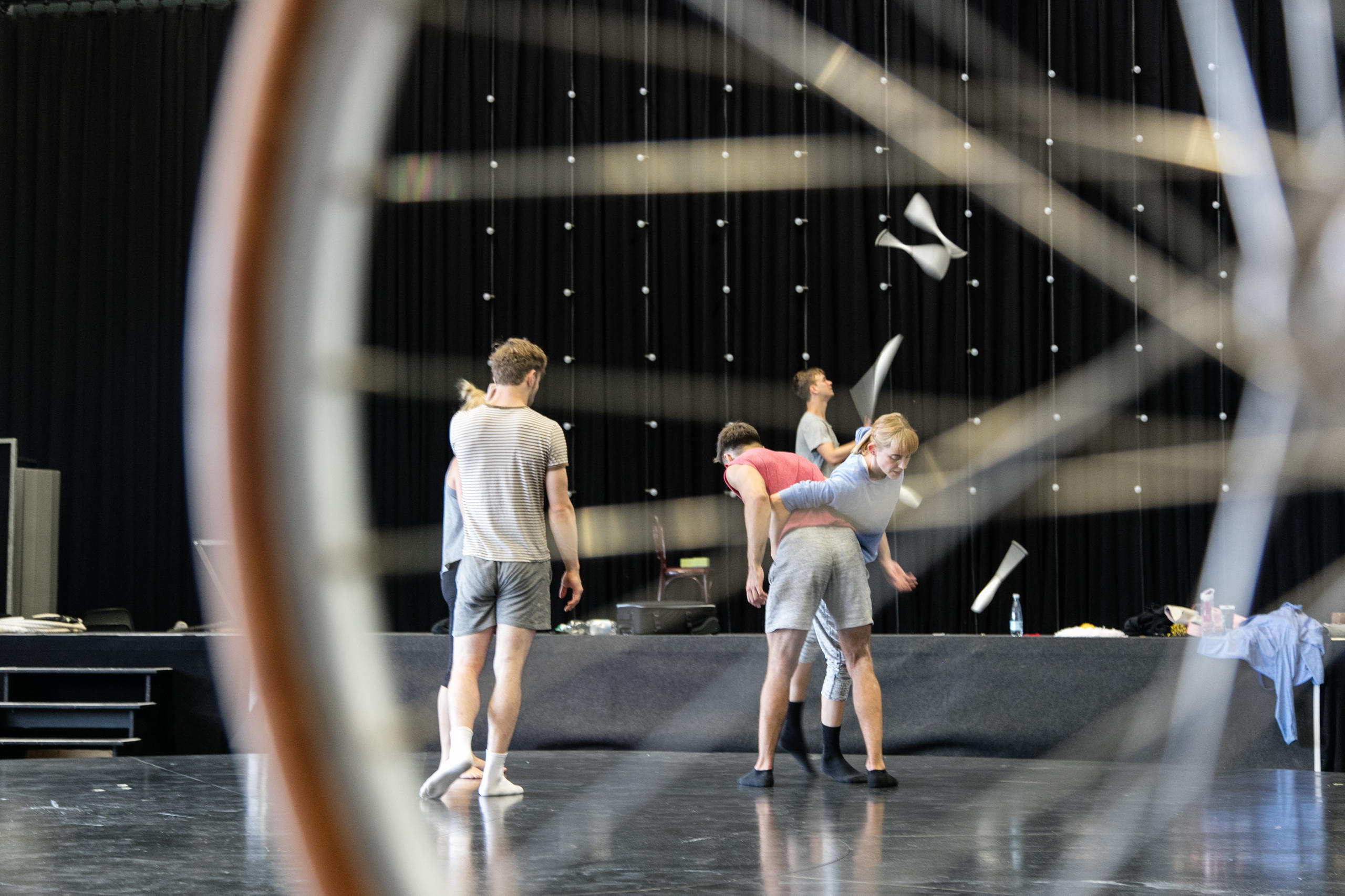 Artistes de cirques photographiés à travers une roue de vélo.