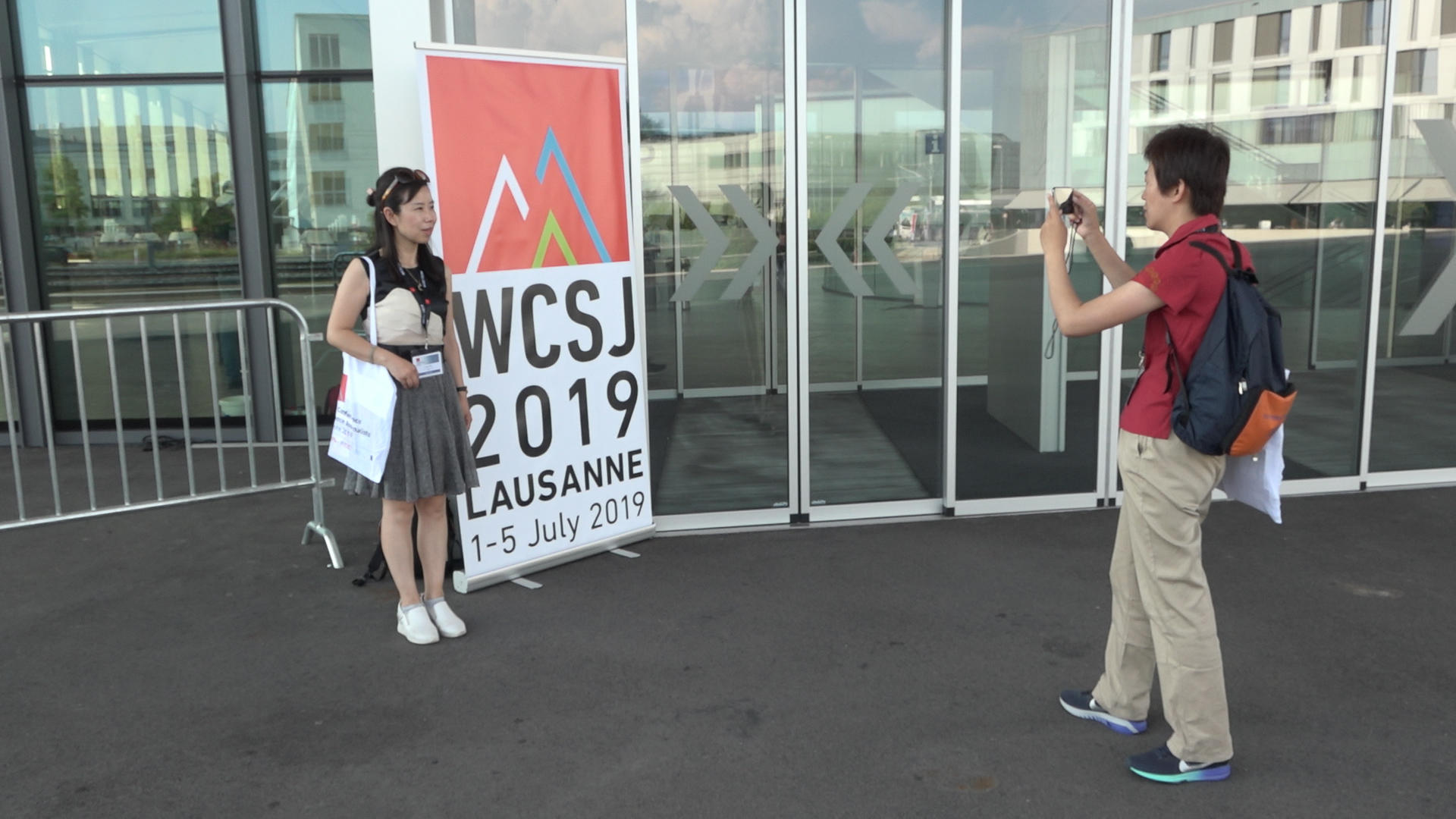 Journalists standing near conference sign taking photo