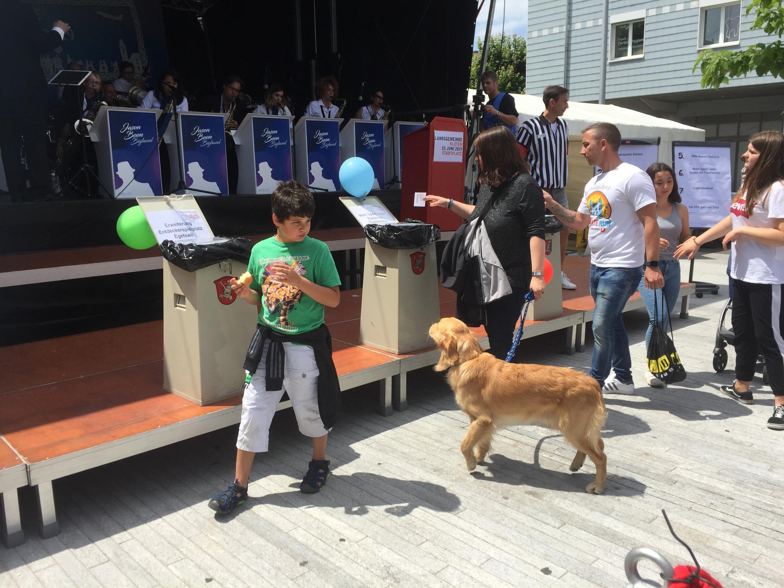 Mutter, Kind und Hund an der Landsgemeinde Kloten beim Abstimmen über die Bürgerprojekte