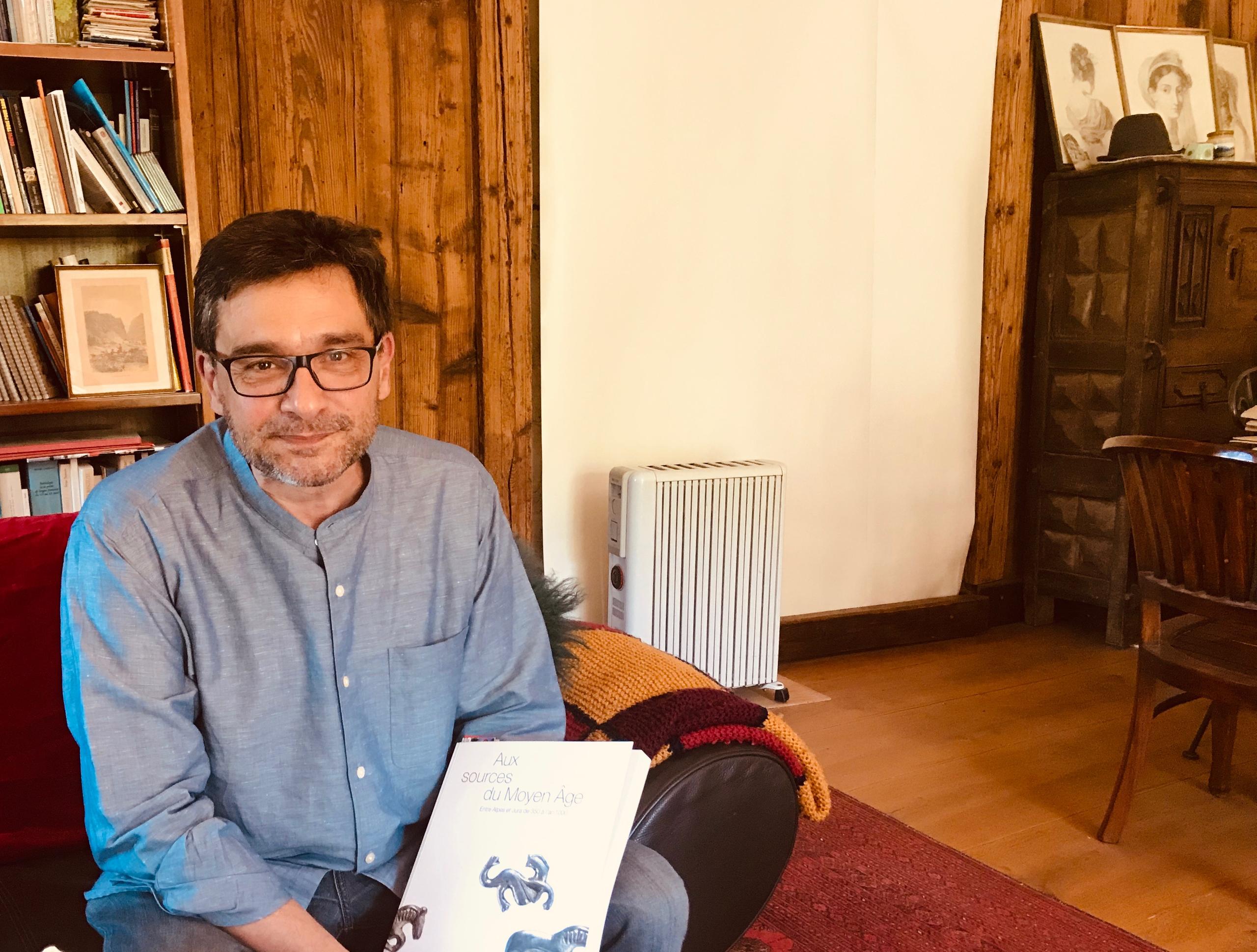 Homme assis posant avec un livre