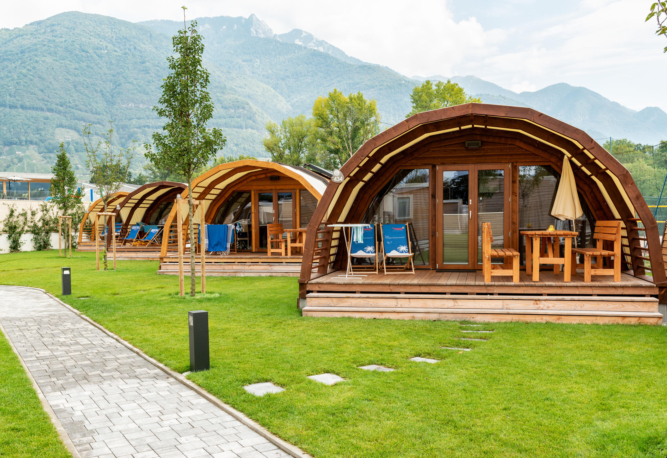 Kleine, halbröhrenförmige Holzhäuser auf einem Campingplatz