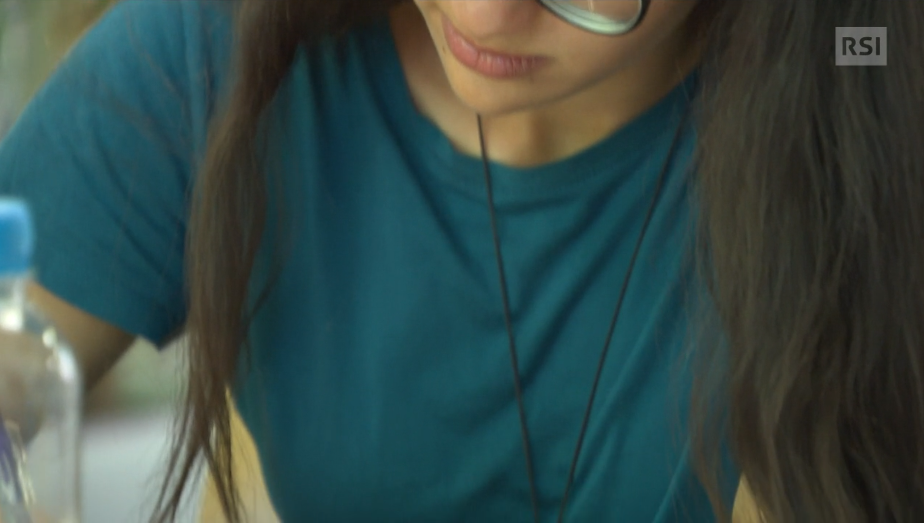 Due ragazze (una guarda il cellulare, l altra sfoglia un dépliant, fotografate all aperto