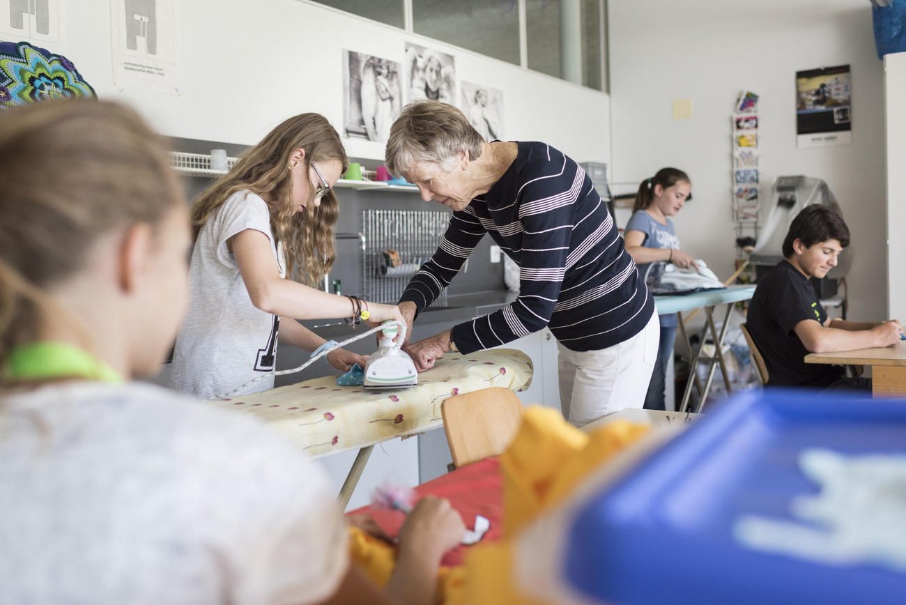 Old lady helping a young girl with the ironing