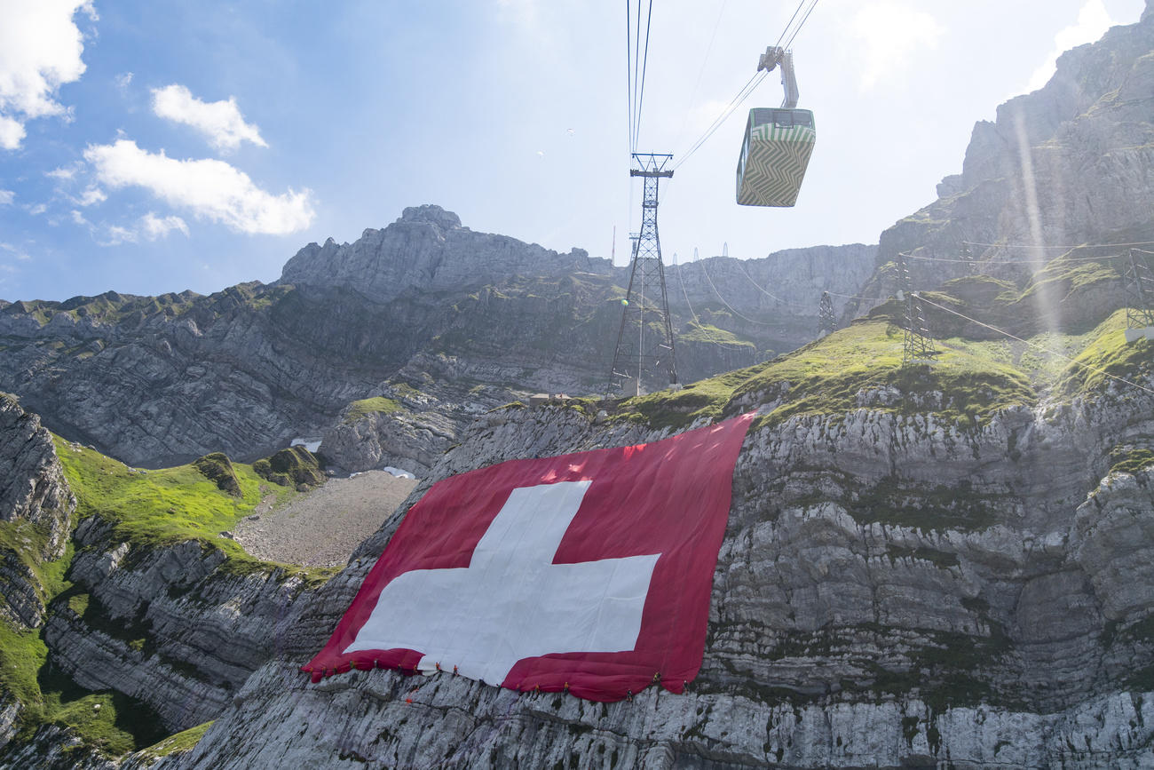 La bandiera svizzera mentre viene srotolata sul Säntis.