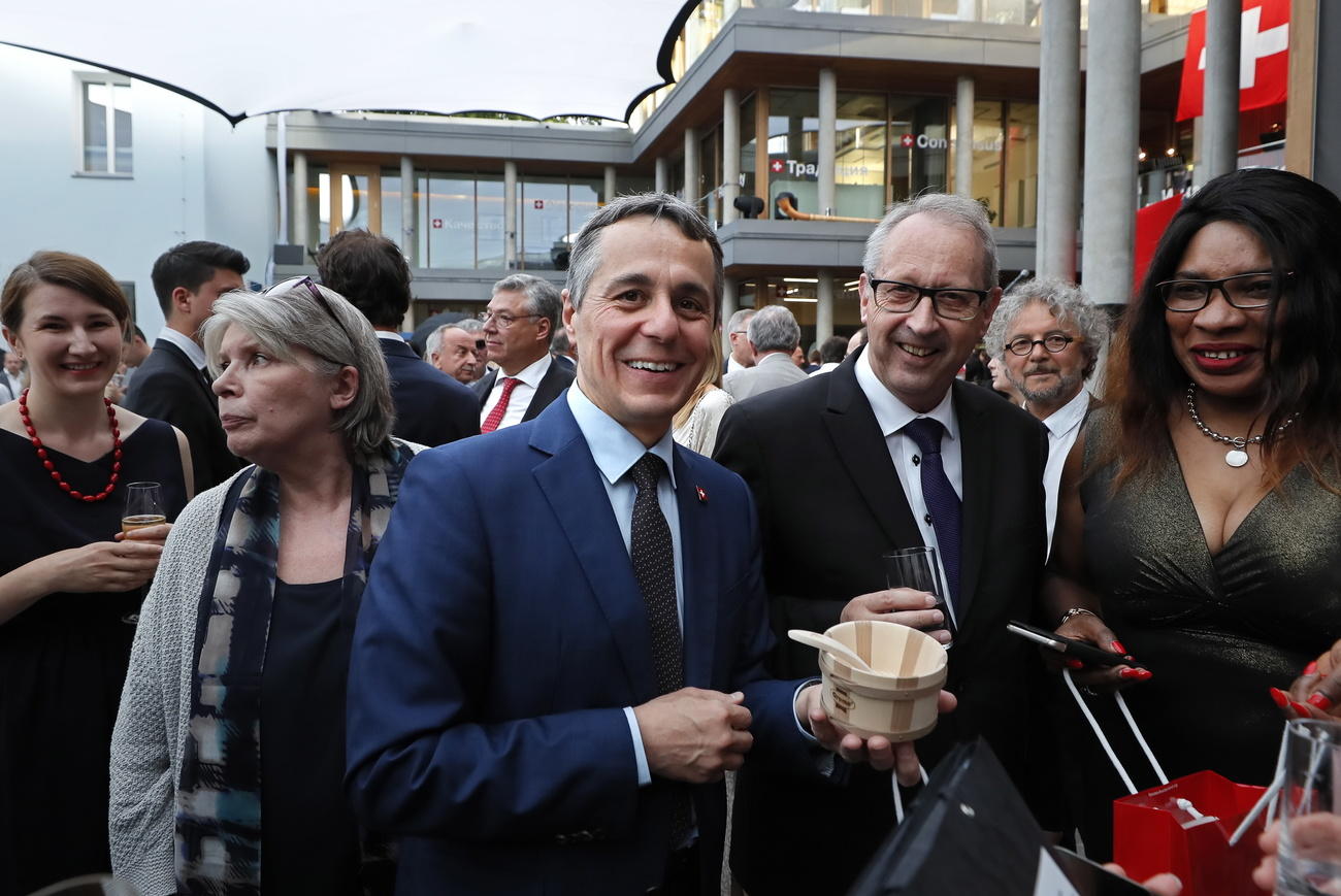 وزير الخارجية السويسري وسط مجموعة من الرجال اوالنساء في حفل افتتاح السفارة السويسرية في موسكو