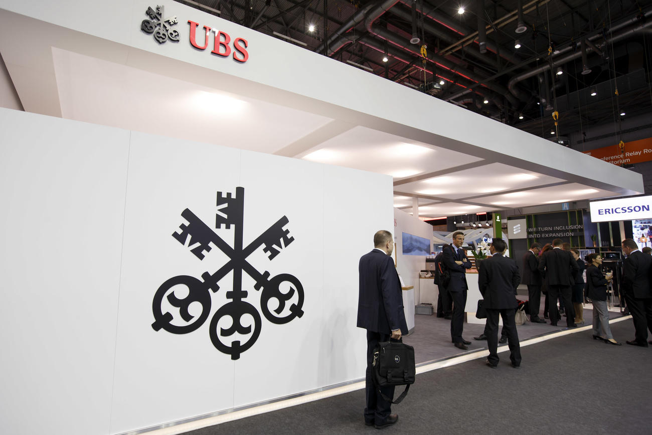 Visitors and exhibitors are seen gathering at the UBS booth